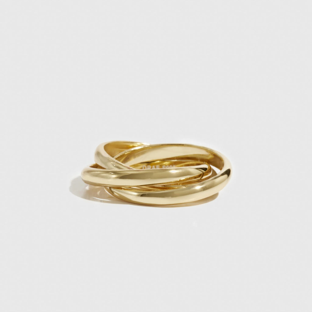 Three gold rings stacked on a light gray background