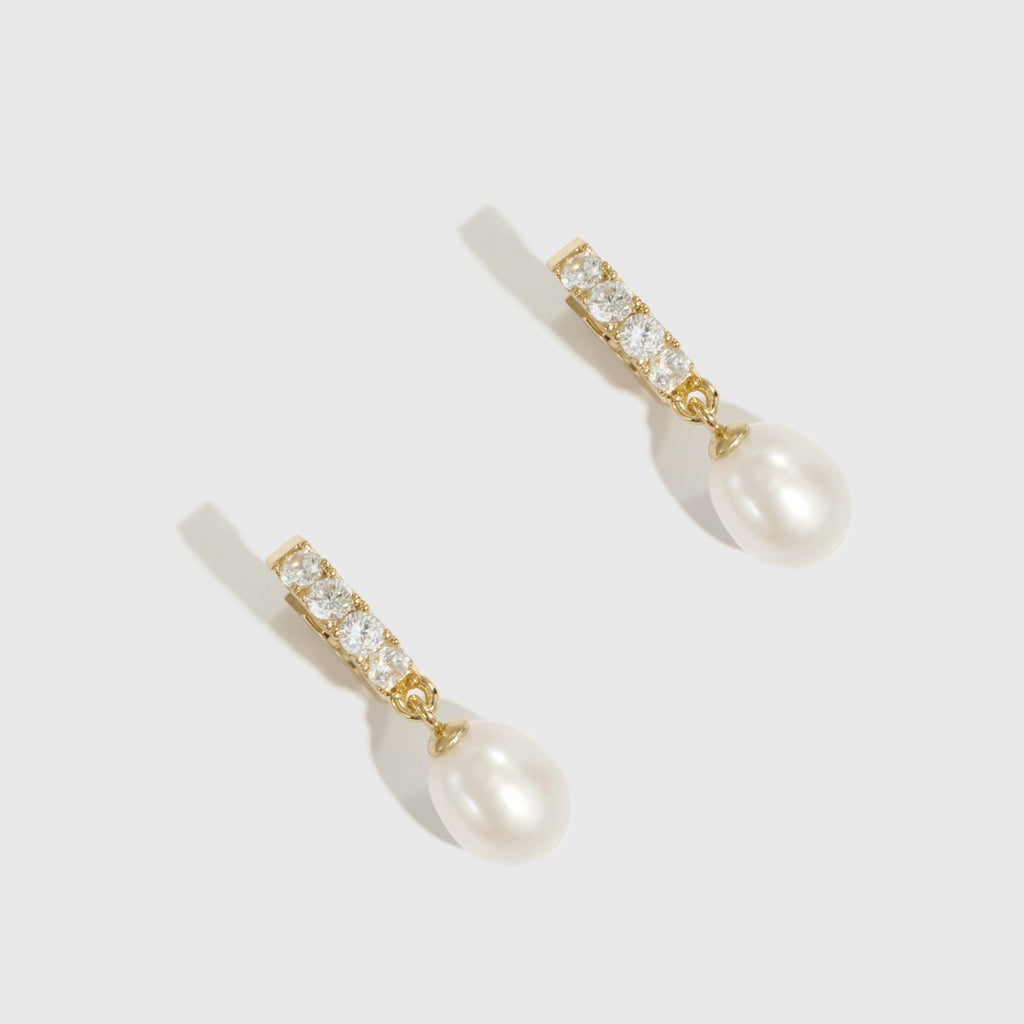 Pearl and crystal drop earrings on a white background